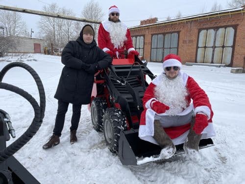 Команда рядом с колёсным погрузчиком RED на новогоднем архивном снимке